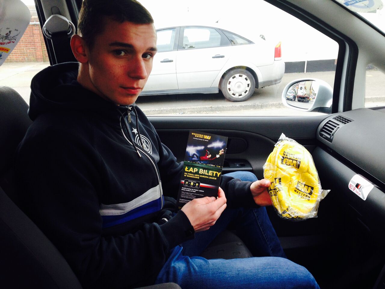 A man in a taxi holding a Western Union leaflet