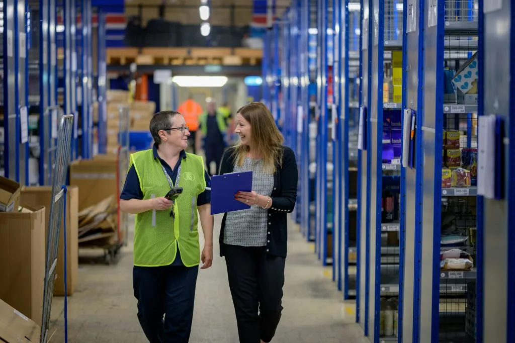 Two warehouse employees discussing operations in a logistics center, illustrating Poland’s growing warehousing and supply chain industry.