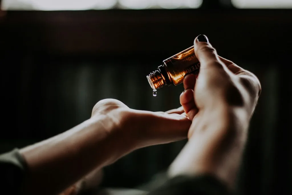 Close-up of hands pouring essential oil, symbolizing Poland’s growing wellness industry and focus on natural health and wellbeing.