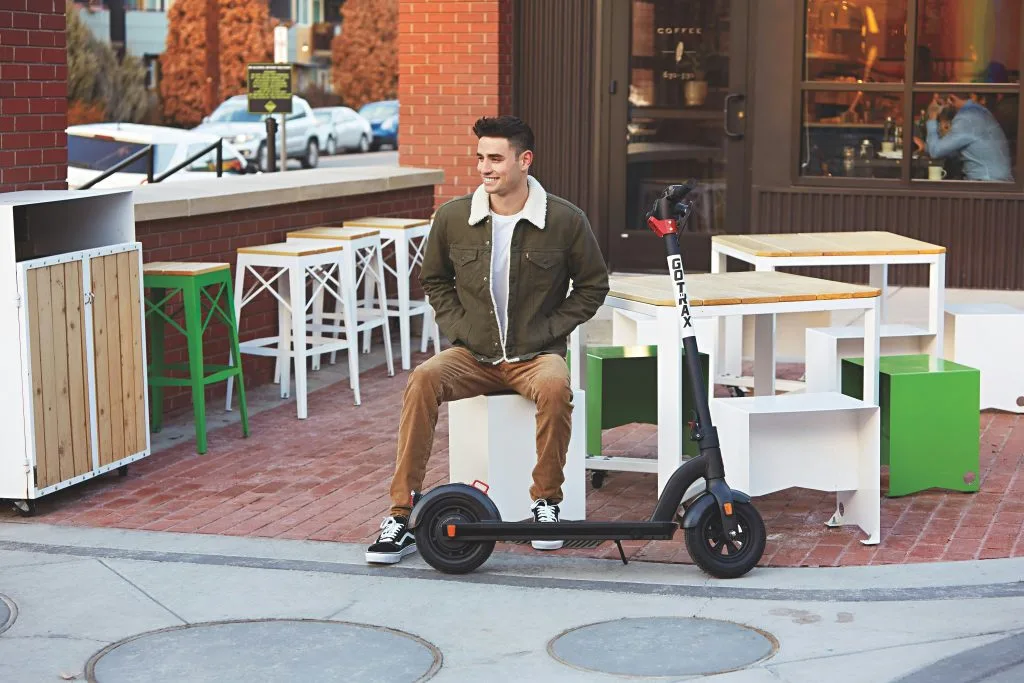 Young man with an electric scooter in an urban setting, representing the rise of e-mobility and sustainable transport in Poland.