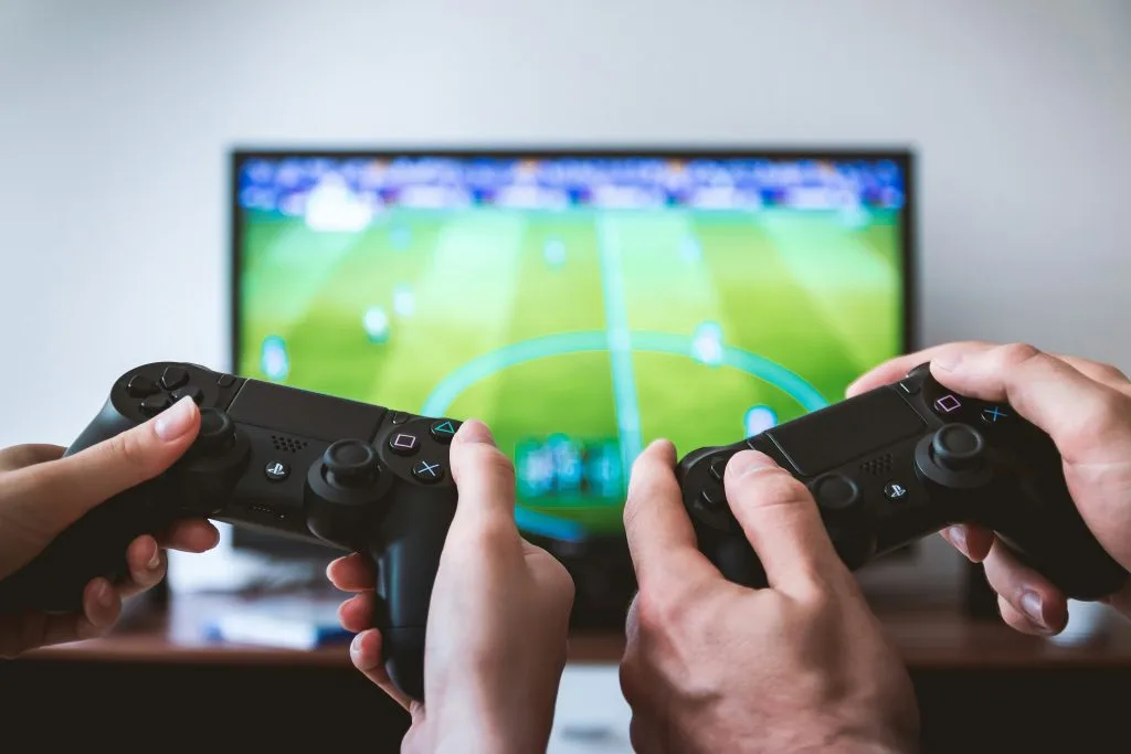 Two people playing a video game with controllers, representing Poland’s thriving gaming industry and creative digital exports.