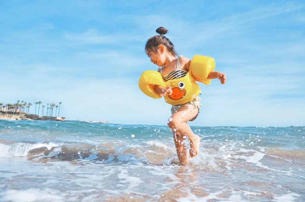 Child playing at the seaside on a sunny day, representing Poland’s growing tourism and travel industry.