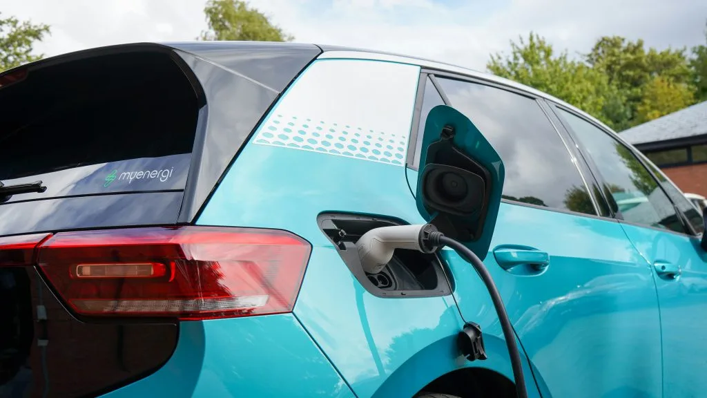 Close-up of an electric car charging at a home EV charger with cable plugged into the vehicle