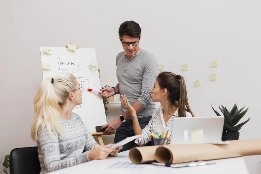 Business professionals reviewing charts and presenting communication strategy during a team meeting