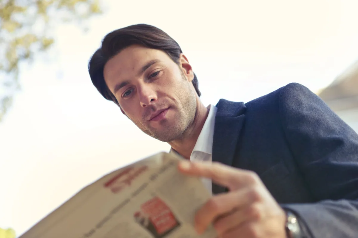 Man reading a delivery package label outdoors
