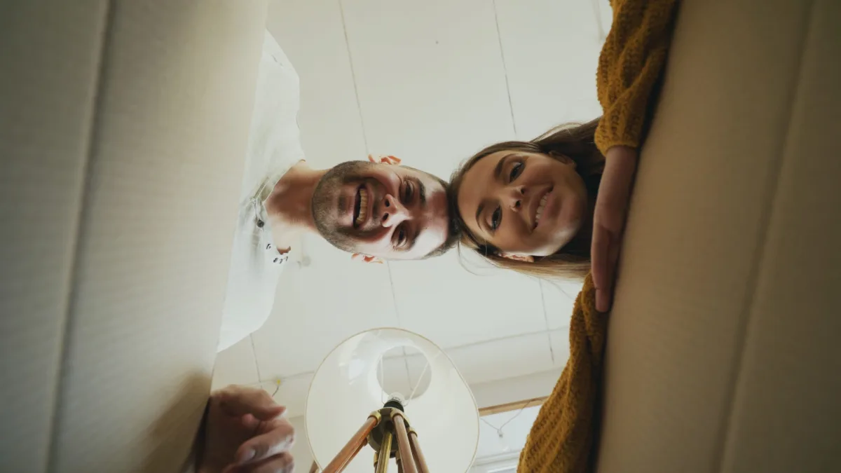 Smiling young couple looking down into an open moving box