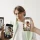 Person posing while being photographed with multiple smartphones